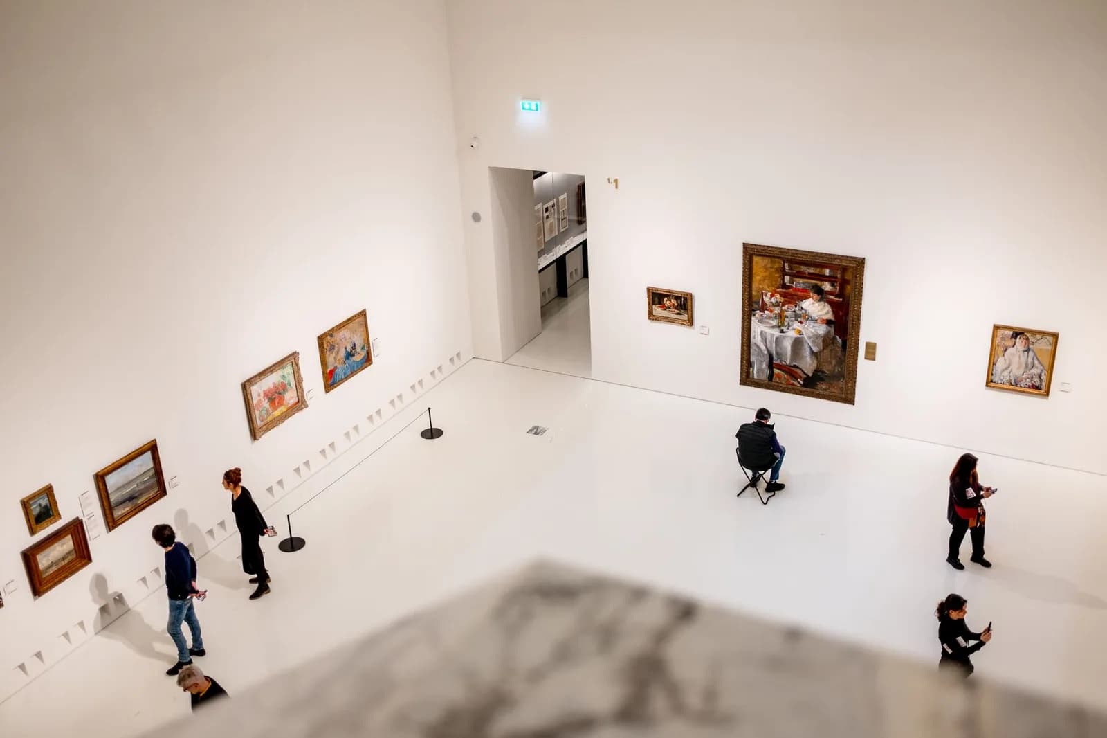 A museum gallery seen from above, where each visitor is having a different visit at the same moment
